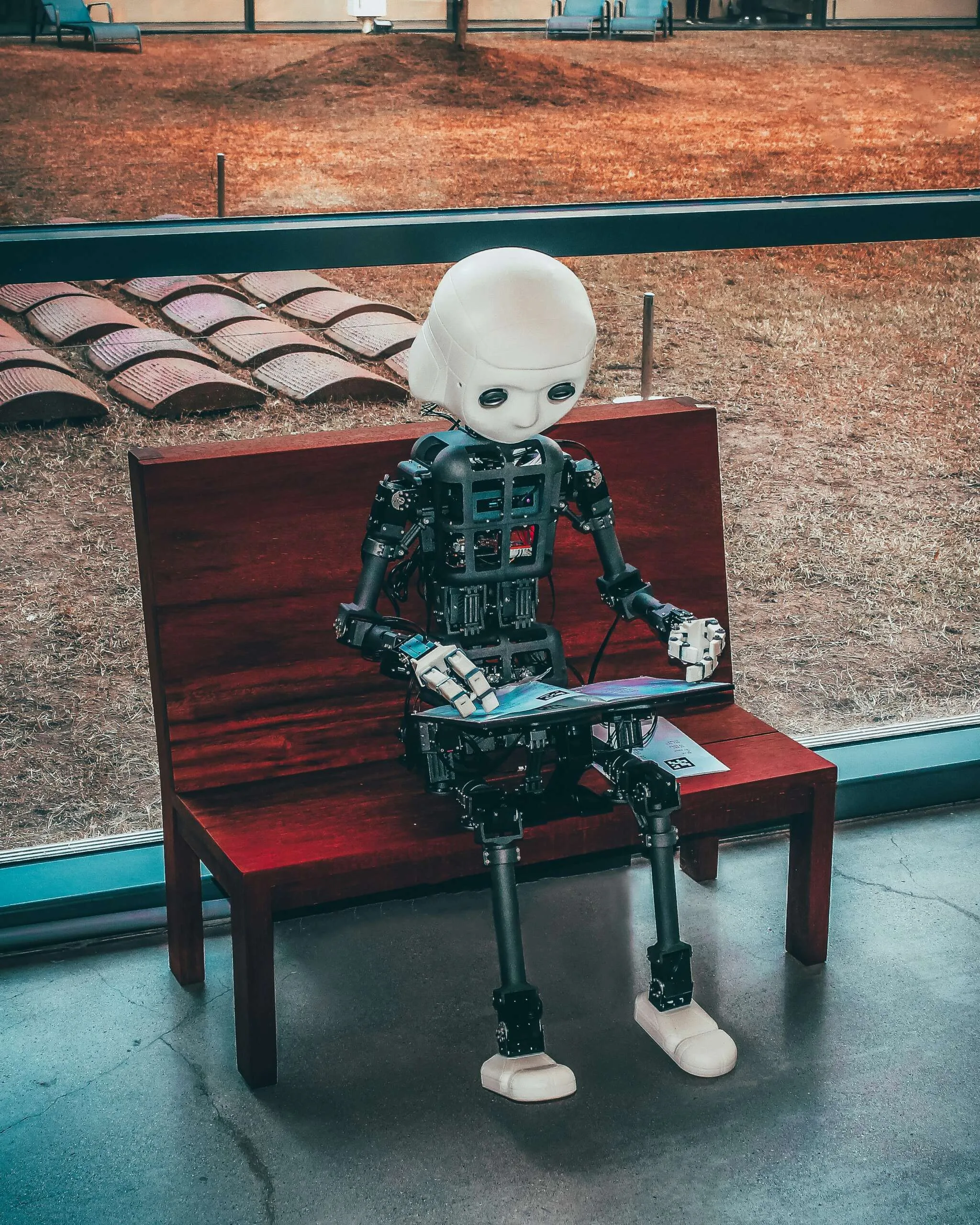 humanisasi AI - black and white robot toy on red wooden table
